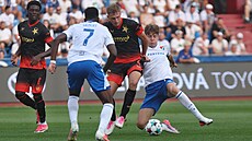 Slávistický obránce David Zima se prodírá mezi fotbalisty Baníku.