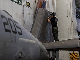 Americký mari�ák provádí údr�bu letounu F-35C Lightning II v hangáru letadlové...