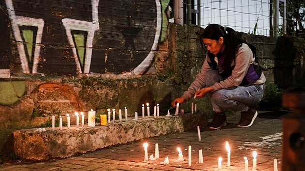 �ena zapaluje sv��ky na ulici po zem�t�esen� v kolumbijsk�m Manizales. (10. srpna 2026)