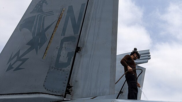 Americk� n�mo�n�k myje letoun EA-18G Growler na palub� letadlov� lodi t��dy USS Abraham Lincoln. (9. srpna 2026)