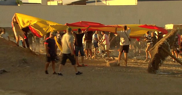 Migranti se v Ceutě skrývají v kopcích nad pláží. Místní lidé jim zapálili přístřešky