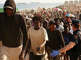 Migranti opou�t�jí provizorní tábo�i�t� na plá�i a mí�í do p�íst�e�k� z�ízených...