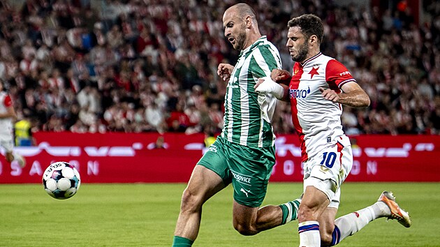Obr�nce David Lischka z Bohemians hl�d� m�� p�ed Danijelem �turmem ze Slavie.