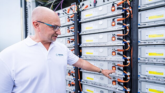 Ivo Apfel ze spole�nosti Tesla Energy Group u bateriov�ho �lo�i�t� ve Velk� B�te�i. Ukazuje na moduly, kter� tvo�� celkovou kapacitu 27 MWh. (9. z��� 2026)