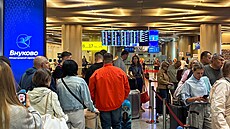 Cestující stojí ve front� u odbavovacích p�epá�ek na mezinárodním leti�ti...