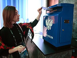 �ena vhazuje dopis do po�tovní schránky Moskv�. (4. listopadu 2024)