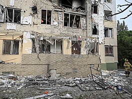Záchraná� prochází místem u obytného domu po�kozeného p�i ruském dronovém útoku...