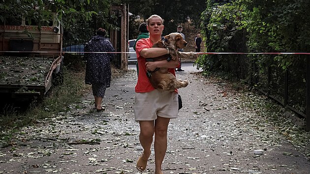 Obyvatelka vyn�� psa z domu po�kozen�ho p�i rusk�m dronov�m �toku v Od�se. (13. z��� 2026)