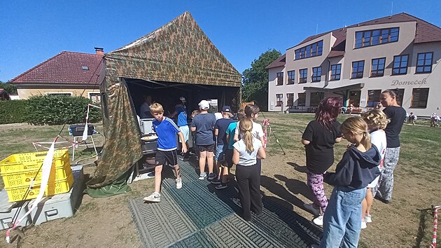 ��ci ze z�kladn� �koly v Chlumu u T�ebon� ob�dvaj� ve vojensk�ch stanech p�ed budovou. �koln� kuchyn� se toti� opravuje.
