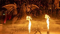 Pozor na n�j! Nástup hokejist� Fribourgu doprovází dra�í figurína.