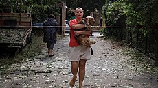 Obyvatelka vyná�í psa z domu po�kozeného p�i ruském dronovém útoku v Od�se....