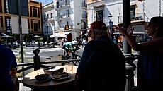 Diváci p�ímo z restaurace sledují závodníky v individuální �asovce v 18. etap�...