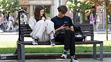 Dva teenage�i sedí na lavi�ce ve Lvov� a prohlí�ejí si mobilní telefony. (24....