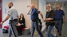 Jan Fi�ara p�ichází p�ed soud v doprovodu policejní eskorty. (21. zá�í 2026)