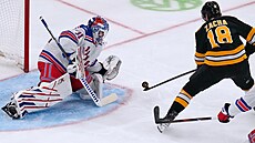 Igor �es�orkin (31) z New York Rangers se v zápase s Boston Bruins pokou�í...