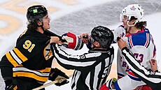 Scott Cherrey od sebe tla�í dva rvá�e, Nikita Zadonov z Boston Bruins vlevo,...