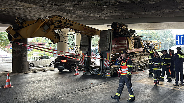 Vyprošťovací tank se pokouší vytáhnout kamion uvázlý pod mostem, doprava v okolí kolabuje