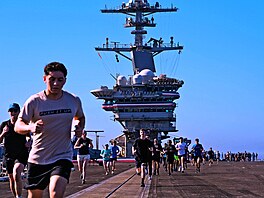 �lenové posádky b�í závod na palub� letadlové lodi USS Abraham Lincoln p�i...