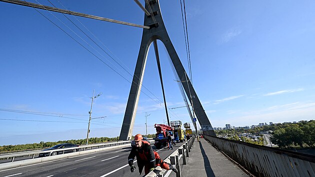 Technici opravuj� trolejbusov� veden�, kter� bylo po�kozeno p�i dronov�m �toku na Severn� most v Kyjev�. (3. ��jna 2026)