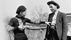 Bonnie Parkerová a Clyde Barrow pózují s brokovnicí.