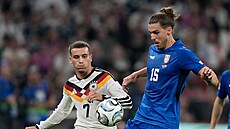 Srbský fotbalista Srdjan Babi� (v modrém) proti N�mecku, do souboje s ním jde...