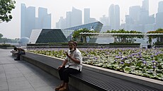 �ena s rou�kou odpo�ívá na lavi�ce ve smogem zasa�eném Singapuru 9. �íjna 2026