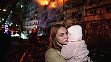 Victoria Deineková dr�í v náru�í svou dceru Miu p�ed bytovým domem po�kozeným...