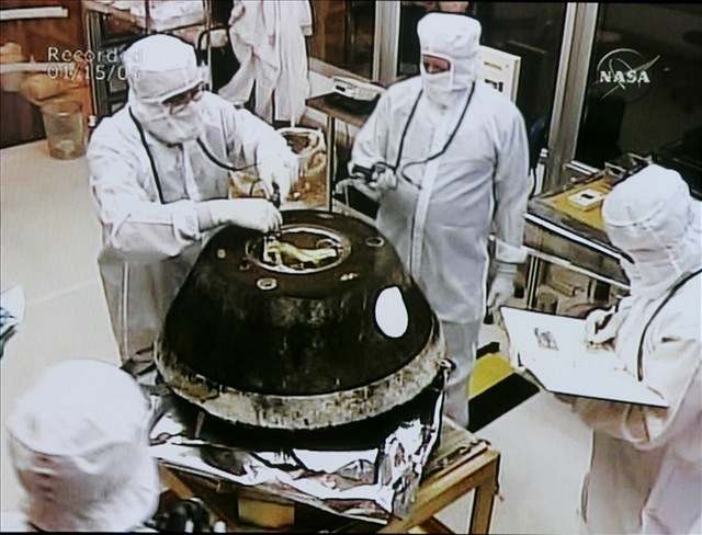 Technici NASA otevírají schránku s prachovými ásticemi.