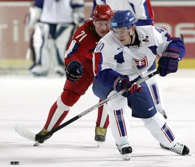 Slovenský úto�ník Marek Svato� uniká ruskému hokejistovi Iljovi Koval�ukovi.