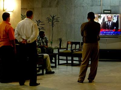 Iráané sledují v televizi projev premiéra Núrí Malikiho.