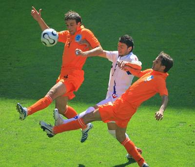 Nizozemští hráči Phillip Cocu a Joris Mathijsen v souboji s útočníkem Srbska a Černé hory Matejem Kezmanem.