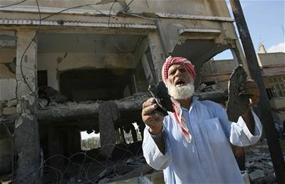 Palestinec ukazuje trosky domu po útoku Izraele.