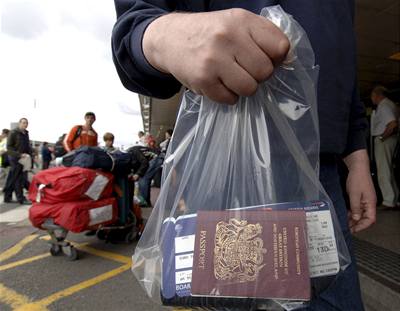 Pracovník letit v Heathrow odnáí zadrené pasy.