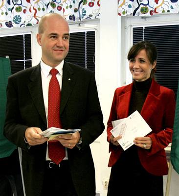 Lídr védské pravicové opozice Fredrik Reinfeldt se svou enou ve volební místnosti.