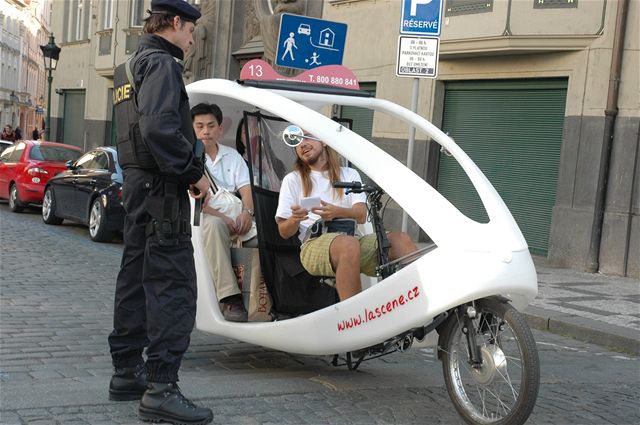 Policista kontroluje turisty - terorismus v Praze.