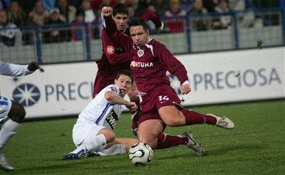 Pavel Horváth se snaží odehrát míč v zápase s Libercem. Pozoruje ho ležící Jiří Bílek.