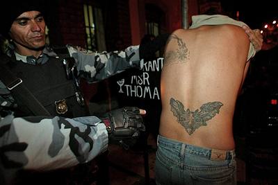 Honduraský policista ukazuje tetování gangu Mara Salvatrucha.