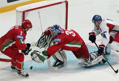 Běloruský gólman Andrej Mezin zasahuje před dotírajícím Davidem Výborným.