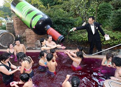 Sommelier Masahiko Mori rozlévá láhev vína Beaujolais Nouveau do bazénu naplnného tímto erveným vínem.