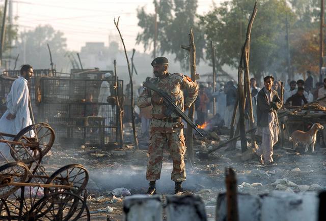 Pákistánský voják hlídkuje uprosted trit, které shoelo pi noních nepokojích. Pi demonstracích u zahynulo 38 lidí. kody se pohybují kolem miliardy rupií.