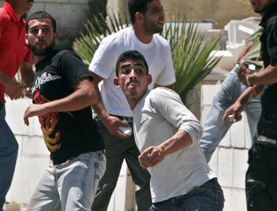 Palestinci házejí na izraelské vojáky kameny po pohřbu sedmnáctiletého Palestince.