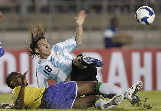 Lionel Messi (modrobílý) bojuje o mí s Brazilcem Juanem.
