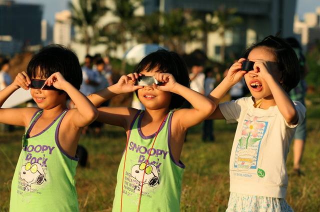 Skupina malých děvčat, sleduje zatmění Slunce na jihovýchodě Číny.