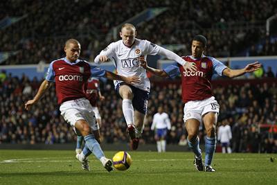 Wayne Rooney (v bílém) z Manchesteru United se probíjí obranou Aston Villy.