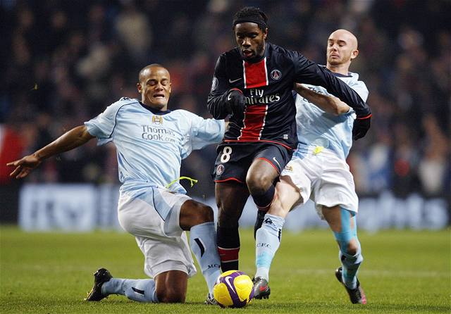 Duo Manchesteru City Kompany (vlevo) a Ireland se snaí zastavit útoníka Paris SG Peguya Luyindulu.