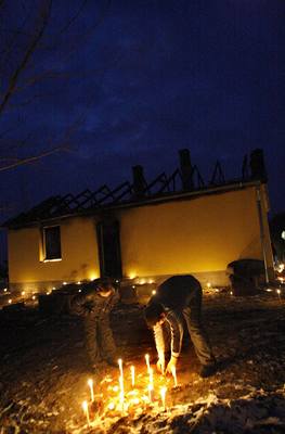 lenové romské rodiny zapalují svíky za mue a jeho dít, zastelené 23. února