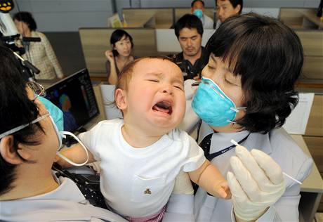 Jihokorejtí lékai odebírají vzorky dítti, které se vrátilo z USA.