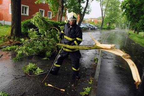 Hasič odstraňuje ulomené větve po bouřce, která 22. května zasáhla Zlín.