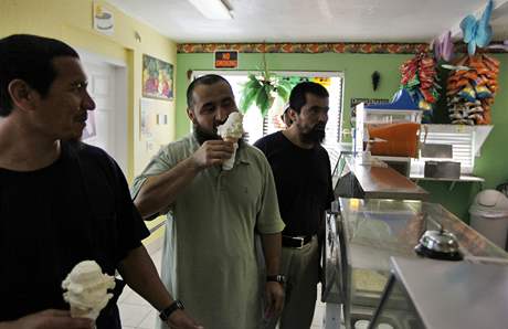 Osvení. trojice Ujgur s chutí pojídá bermudskou zmrzlinu.
