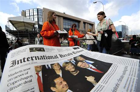 Kameloti rozdávají fiktivní vydání International Herald Tribune.